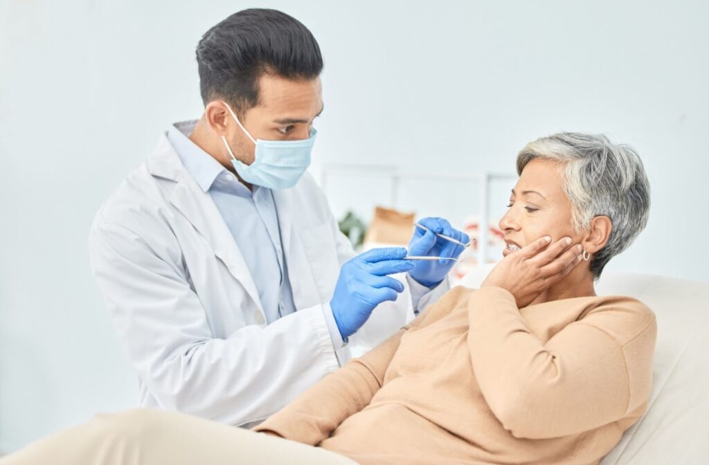 A mature woman consults with her dentist about tooth sensitivity.