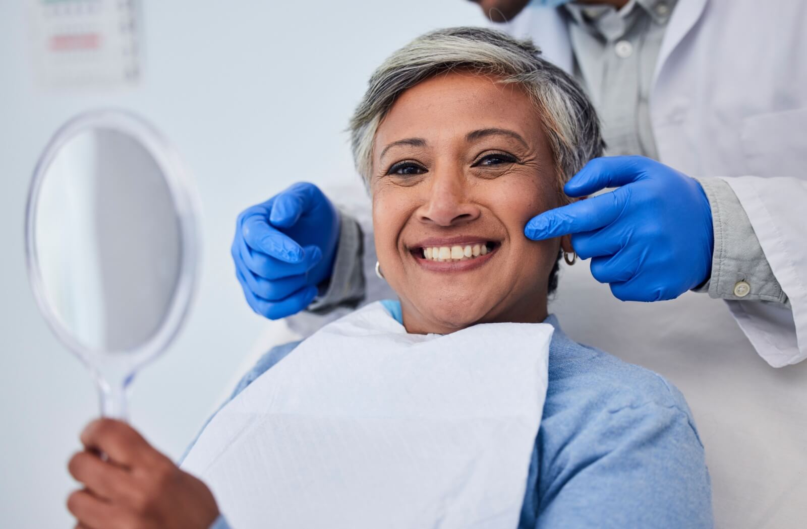 A senior celebrates her new smile after receiving restorative dentistry.