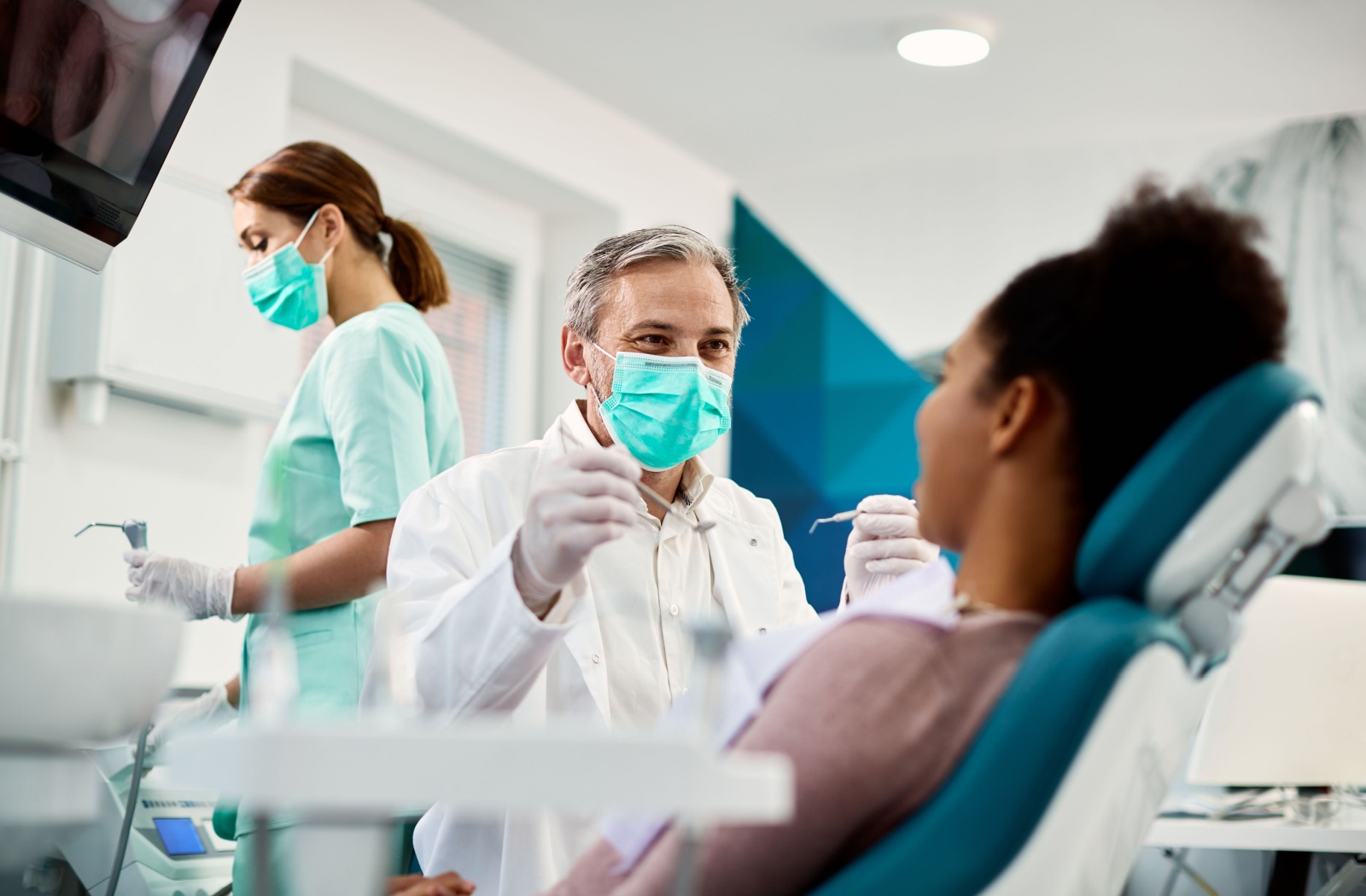 A dentist and their team prepare their patient for a tooth extraction.