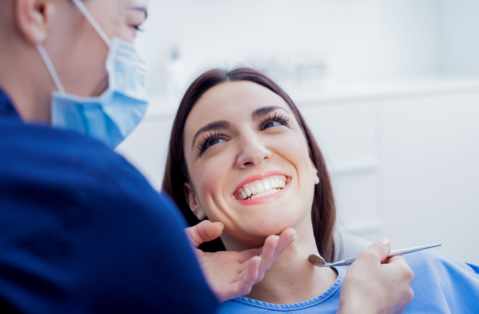 Smiling patient in dental exam chair looking at dentist after a dental filling