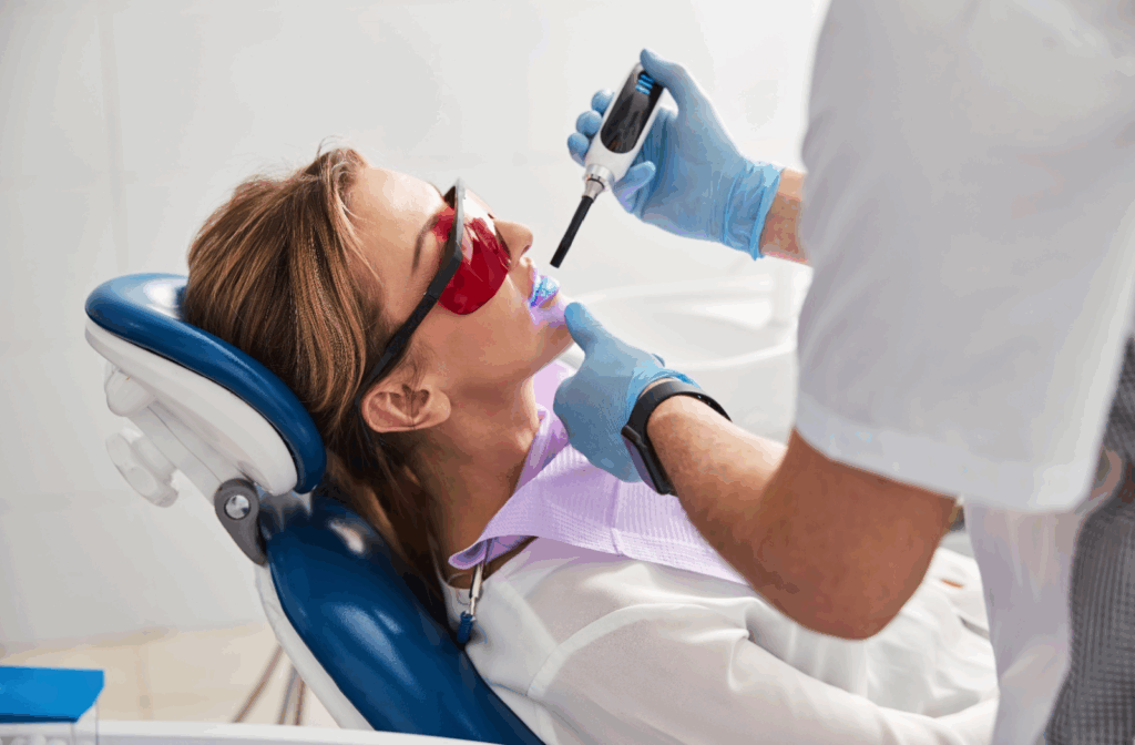 Dentist using a curing light on a patient during a dental filling.